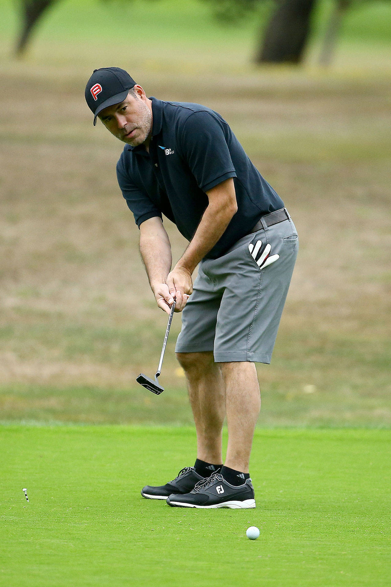 Marc Aparicio follows a putt as it heads to the hole in the Bennett Boyles Golf Tournament. Aparicio is one of the owners of the Penn Cove Brewing Company, which organized the event. (Photo by John Fisken)