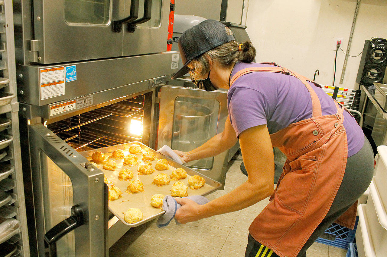 Baker Stefanie Stuchell lifts a tray of gougeres, cheese-filled pastries, from the oven. She is one of the five bakers for Salt Sea Provisions. Photo by Kira Erickson/Whidbey News-Times