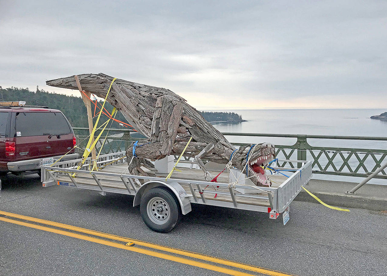 Photo by Scott PriceJoe Treat’s driftwood sculpture of a Tyrannosaurus rex rolls across Deception Pass Bridge Sunday. It was installed Monday morning at Price Sculpture Forest in Coupeville. The park is set to open Oct. 23.