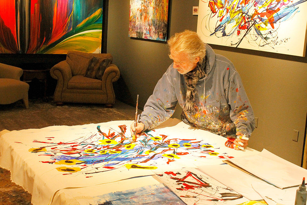Artist Louie Rochon demonstrates the process of how he paints at his Clinton studio on Thursday. Photo by Kira Erickson/Whidbey News-Times