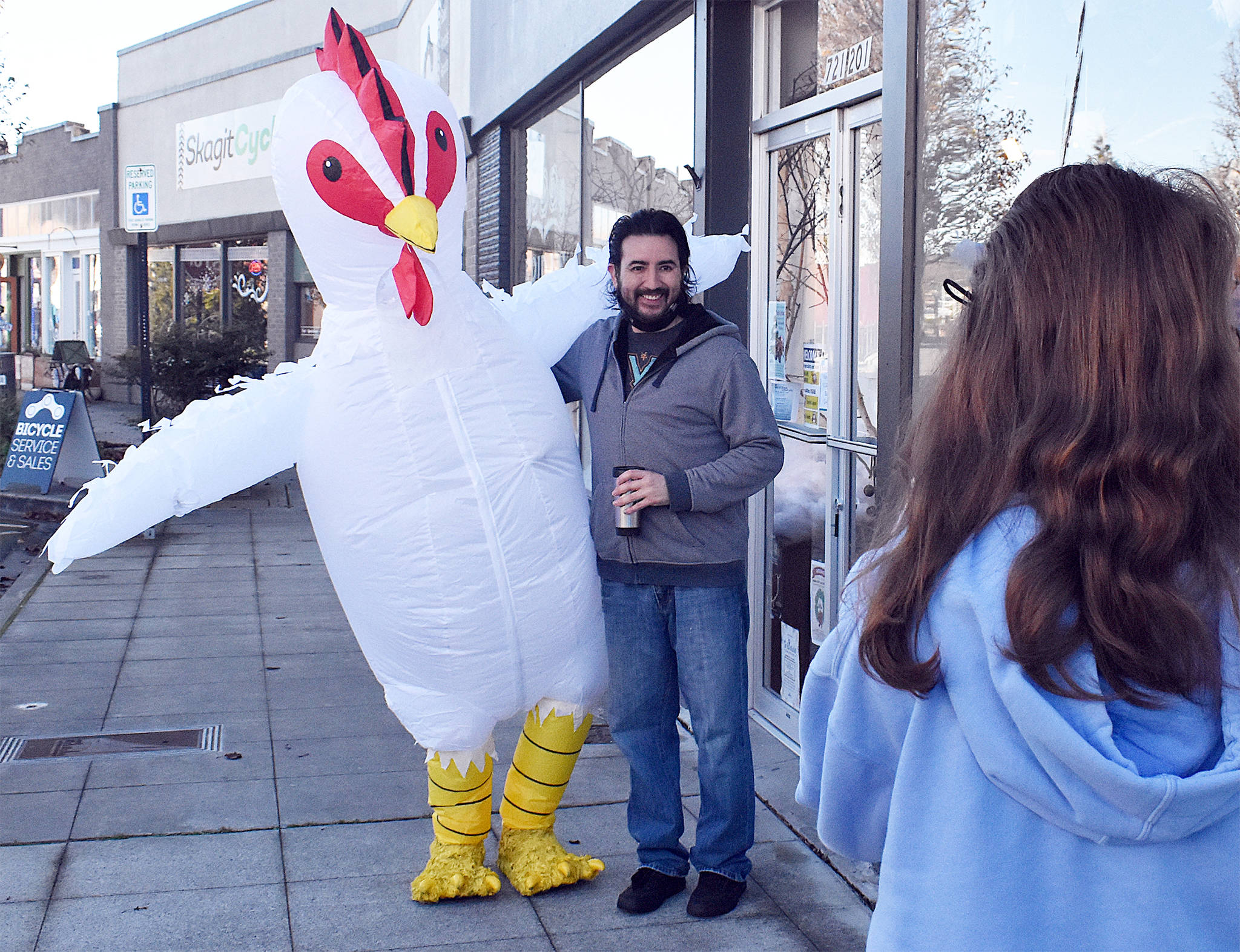 The Whidbey Island Chicken has become somewhat of a local celebrity in recent months, with many fans like Fernando Duran asking for a picture whenever they catch a glimpse. Photo by Emily Gilbert/Whidbey News-Times