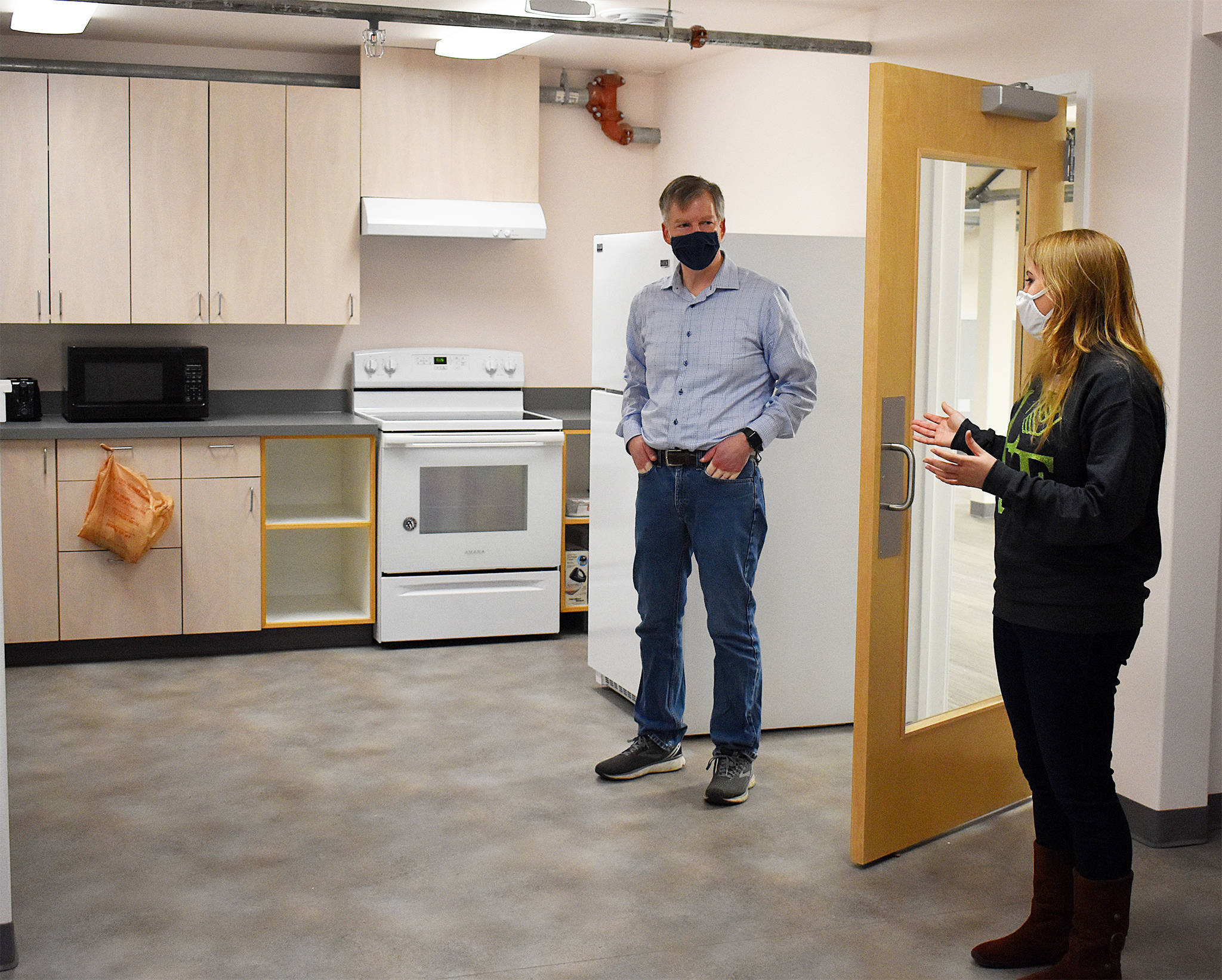State Rep. Dave Paul, D-Oak Harbor, talks to Boys & Girls Club of Oak Harbor Unit Director Nikki Barone about some of the new ways the club will be able to teach kids kitchen skills in its new location on Ely Street. Photo by Emily Gilbert/Whidbey News-Times