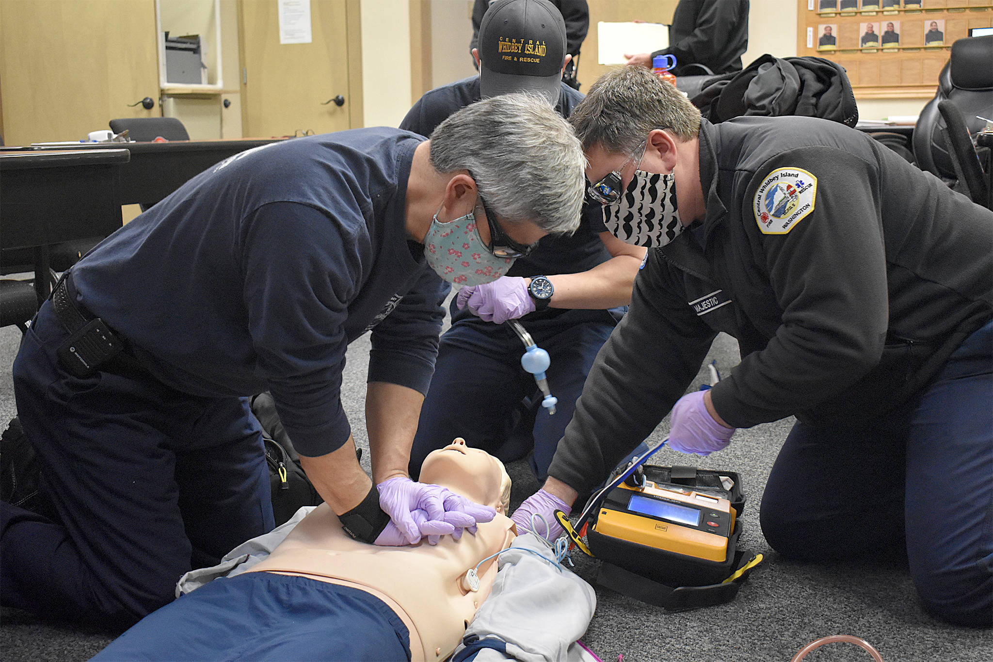 Firefighter Jeff Rhodes (left), Firefighter Keith Dawson (center, back), Acting Lieutenant Alex Majestic (right) practice a CPR response without the LUCAS 3 Chest Compression System the agency wants to buy. Photo by Emily Gilbert/Whidbey News-Times
