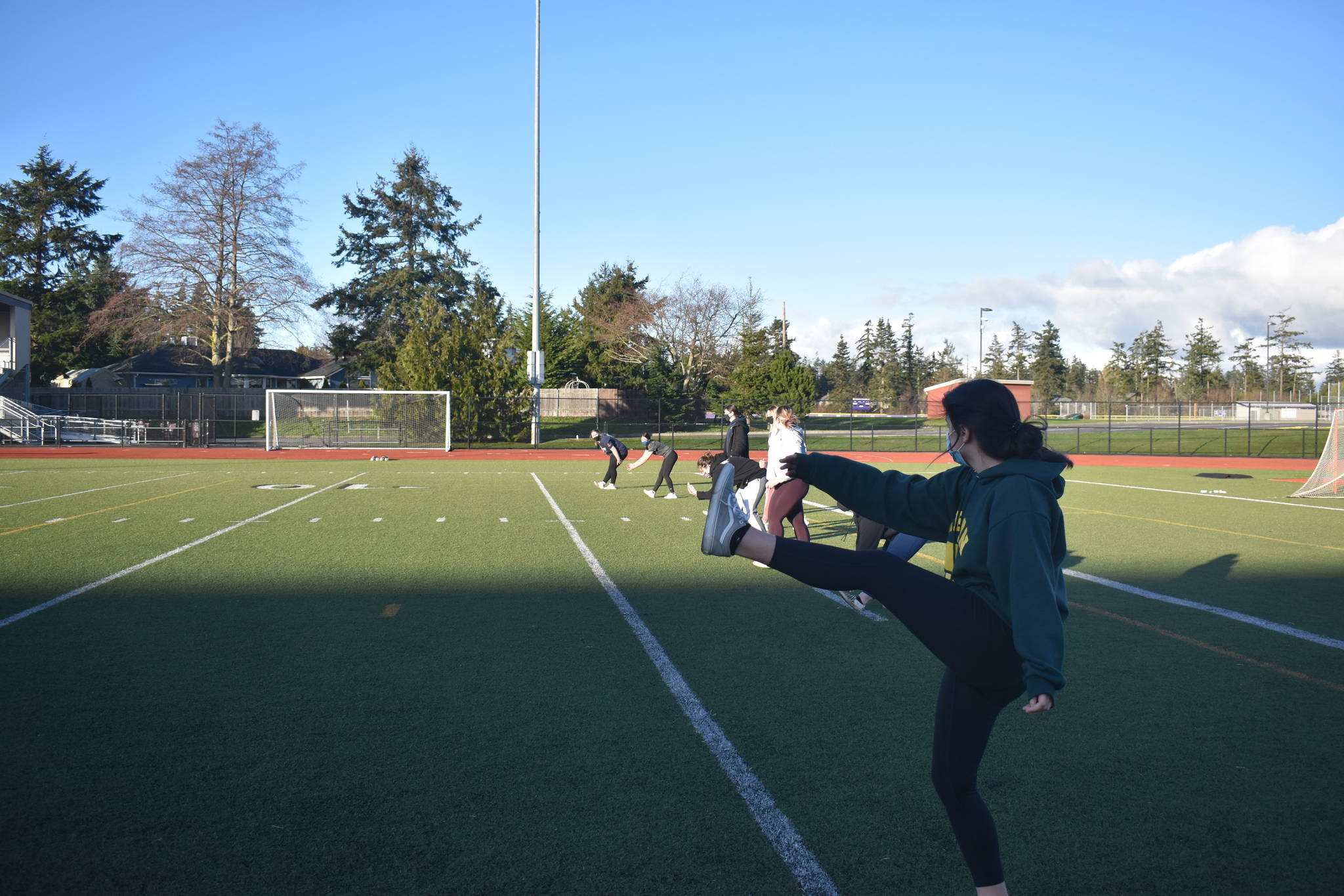 Oak Harbor girls softball team members are allowed to workout together under current COVID-19 restrictions, but are not yet allowed to return to formal practices and competition. School sports may resume this month if Island County and others in the North region can move into Phase 2. Photo by Emily Gilbert/Whidbey News-Times