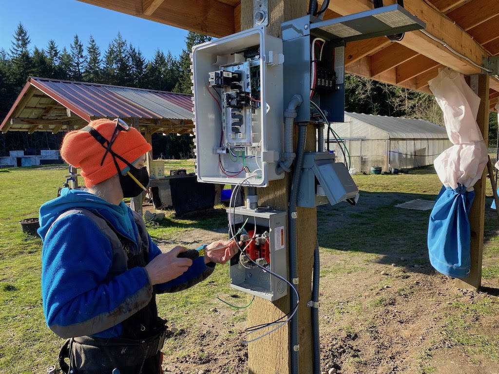Golda Moore of Whidbey Sun and Wind adjusts wiring for the solar panels.