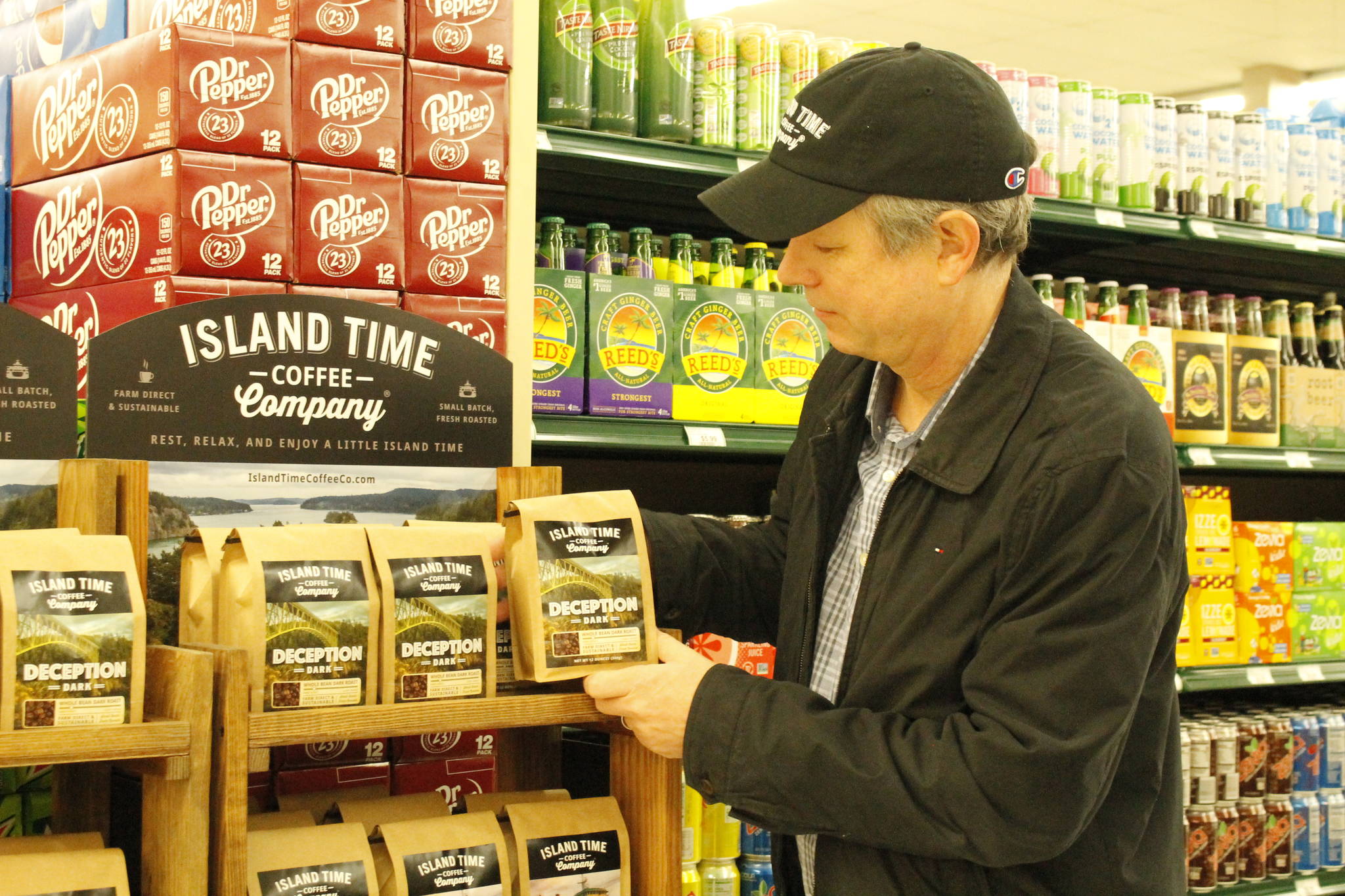 Photo by Kira Erickson/Whidbey News Group
Christopher Baldwin, owner of Island Time Coffee Company, arranges a display in Payless Foods.