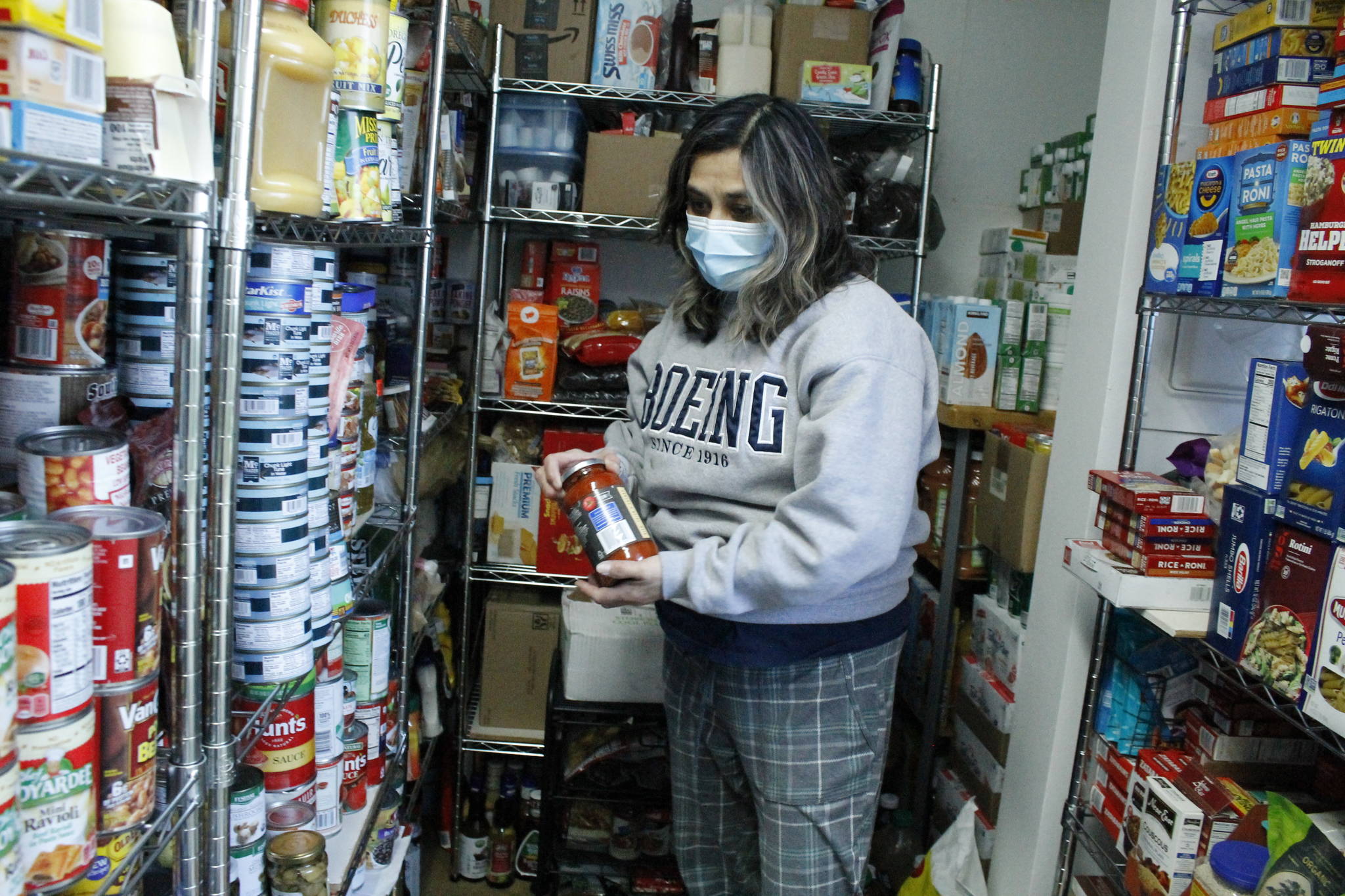 Photo by Kira Erickson/South Whidbey Record
Cindy Buchanan, founder of Whidbey Island Angels, grabs a jar of pasta sauce from the resource centers expansive food pantry.