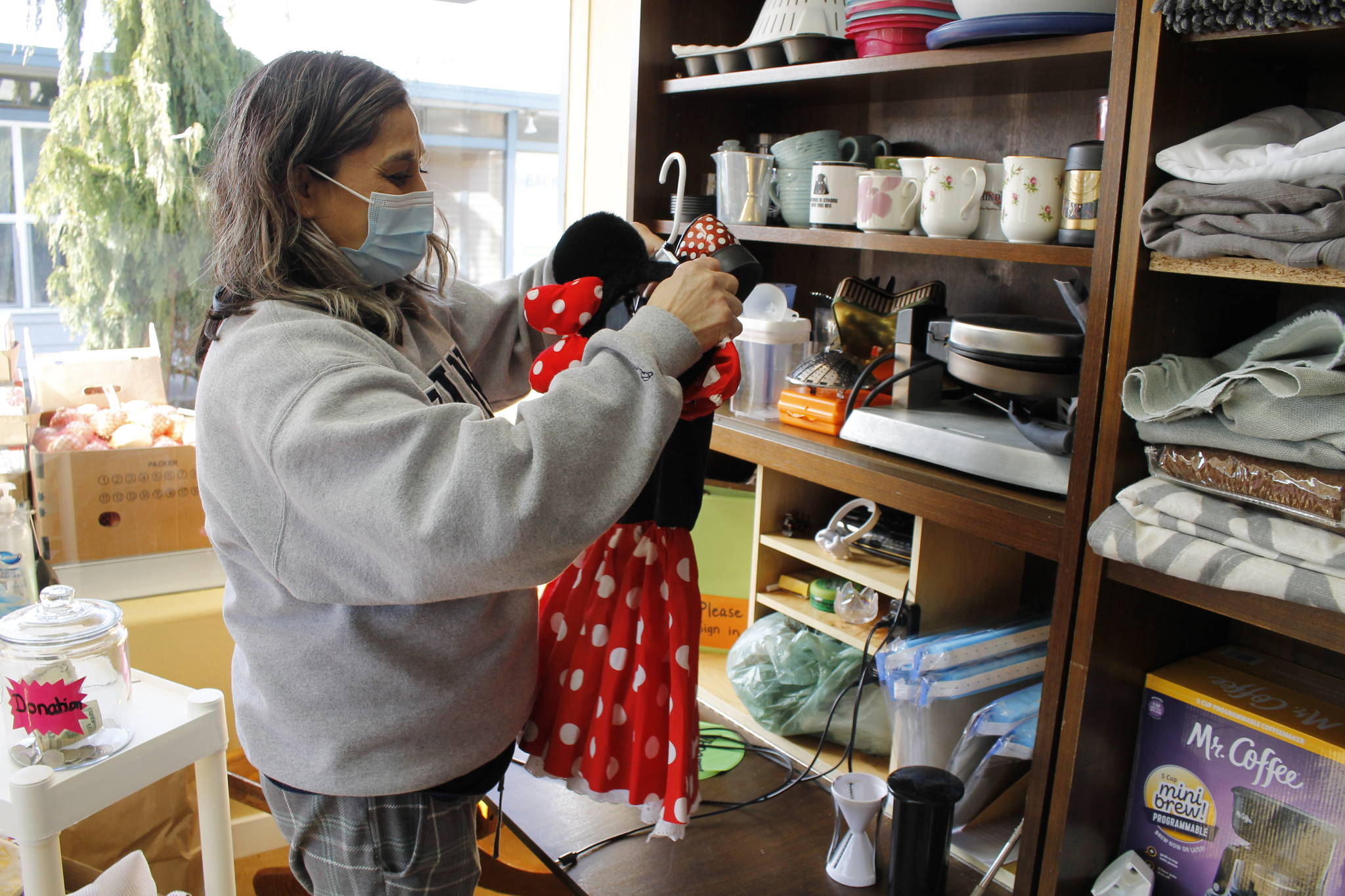 Photo by Kira Erickson/South Whidbey Record
Cindy Buchanan, founder of Whidbey Island Angels, hangs up a toddler's Minnie Mouse outfit.