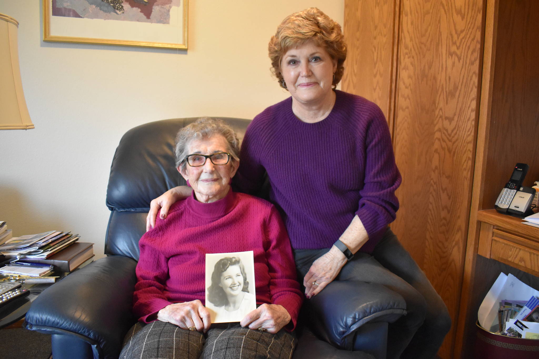 Frances Schultz, holding a picture of her younger self, recently turned 100 years old. Her daughter, Connie Van Dyke, right, said her mother’s photo looks like one of actress Barbara Stanwyck. Photo by Emily Gilbert/Whidbey News-Times