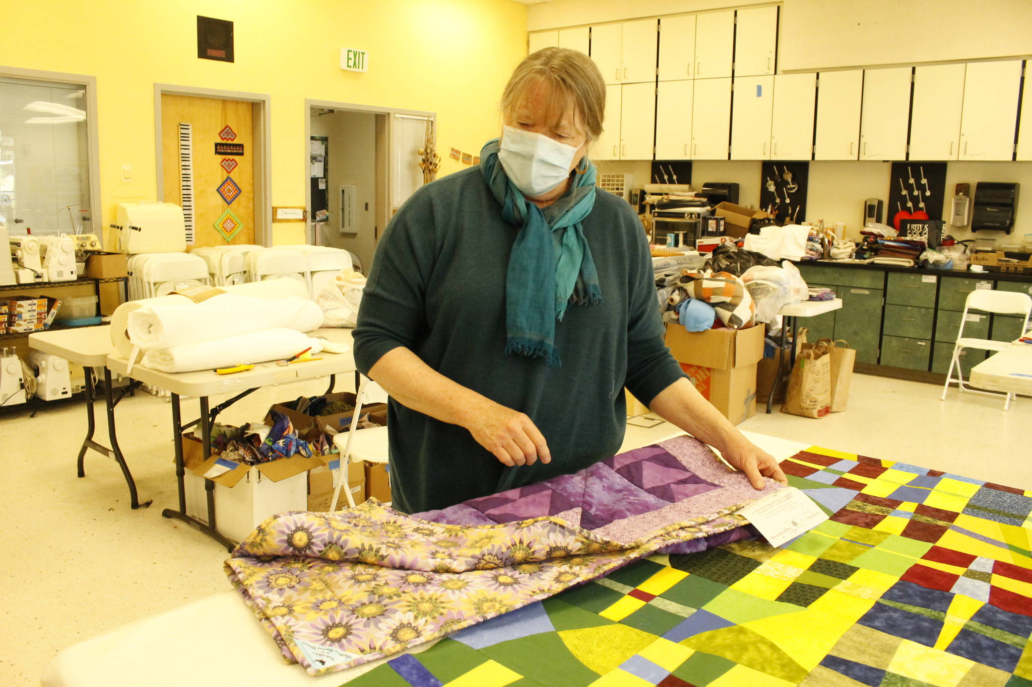 Luanne Seymour shows a few different-sized quilts that the group she helped start, Whidbey Blanket Makers, recently made. (Photos by Kira Erickson/South Whidbey Record)