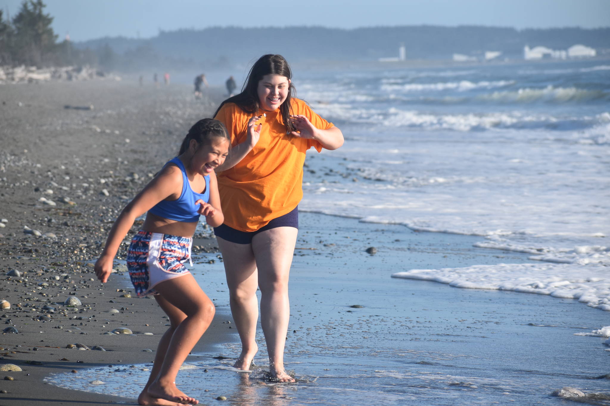 Caraleigh Hernandez, 10, left, and her sister Denelle, 14, play on the beach at Deception Pass State Park. (Photo by Emily Gilbert/Whidbey News-Times)