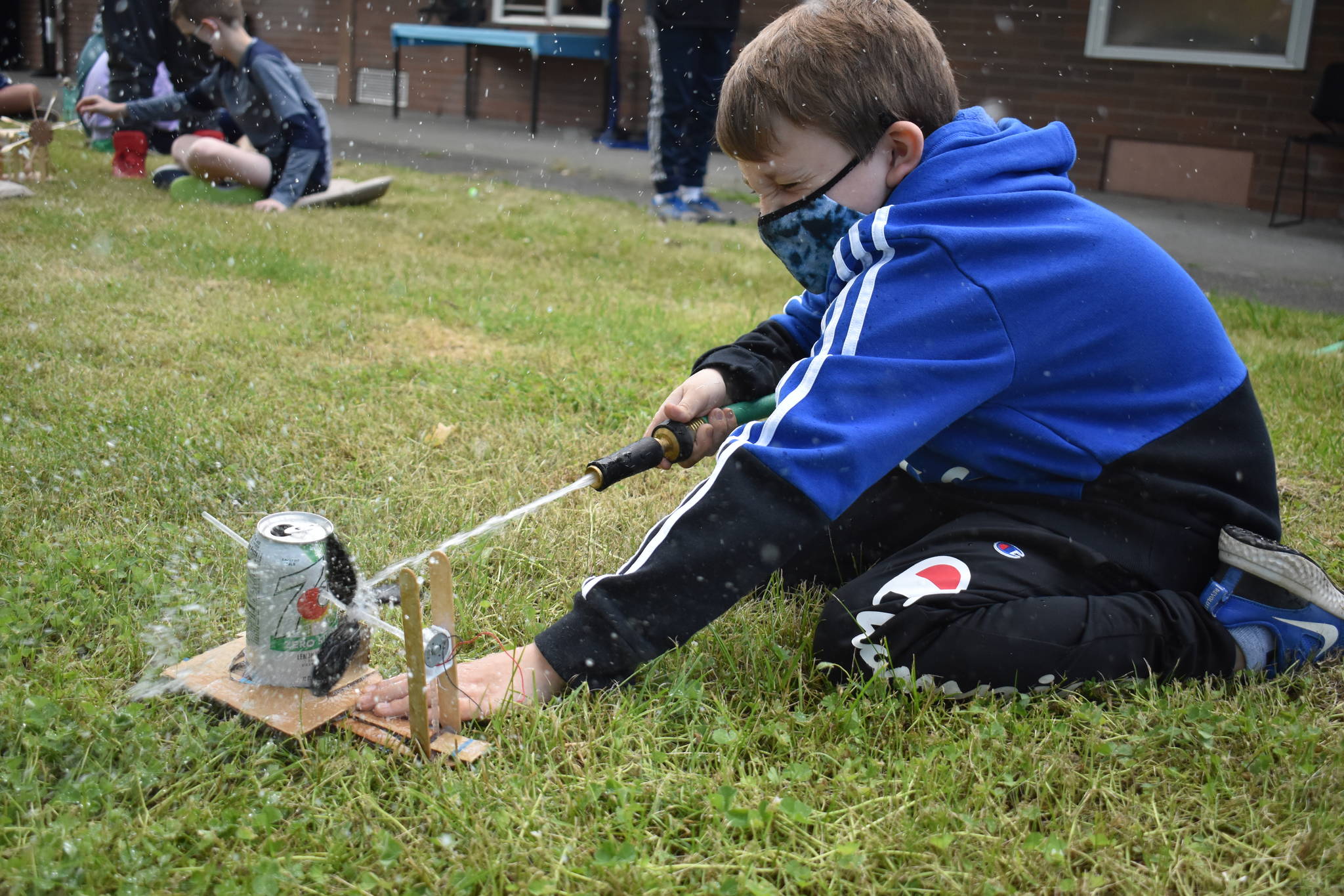 Photo by Emily Gilbert/Whidbey News Group
Fourth-grader Matias Glass uses a garden hose to test his water wheel contraption that he made to learn about alternative energy sources. South Whidbey Elementary School teacher Jean Cravy picked the topic after the school received a grant from the National Oceanic and Atmospheric Administration to learn about global environmental issues.