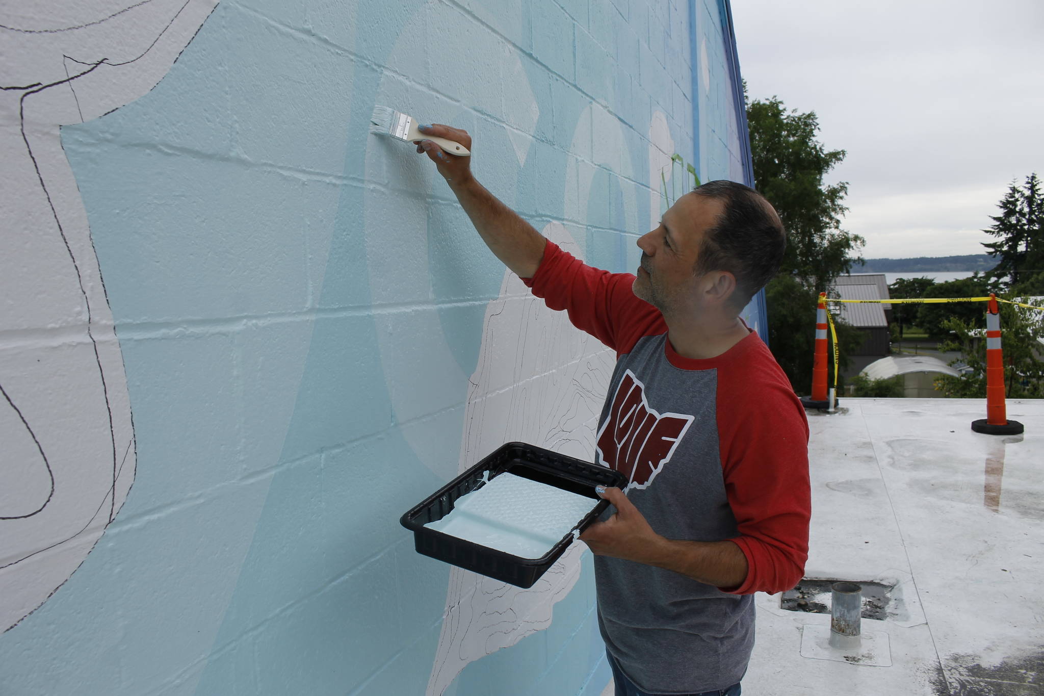 Jeremy Jarvis works on his mural in Langley. (Photo by Kira Erickson/Whidbey News-Times)