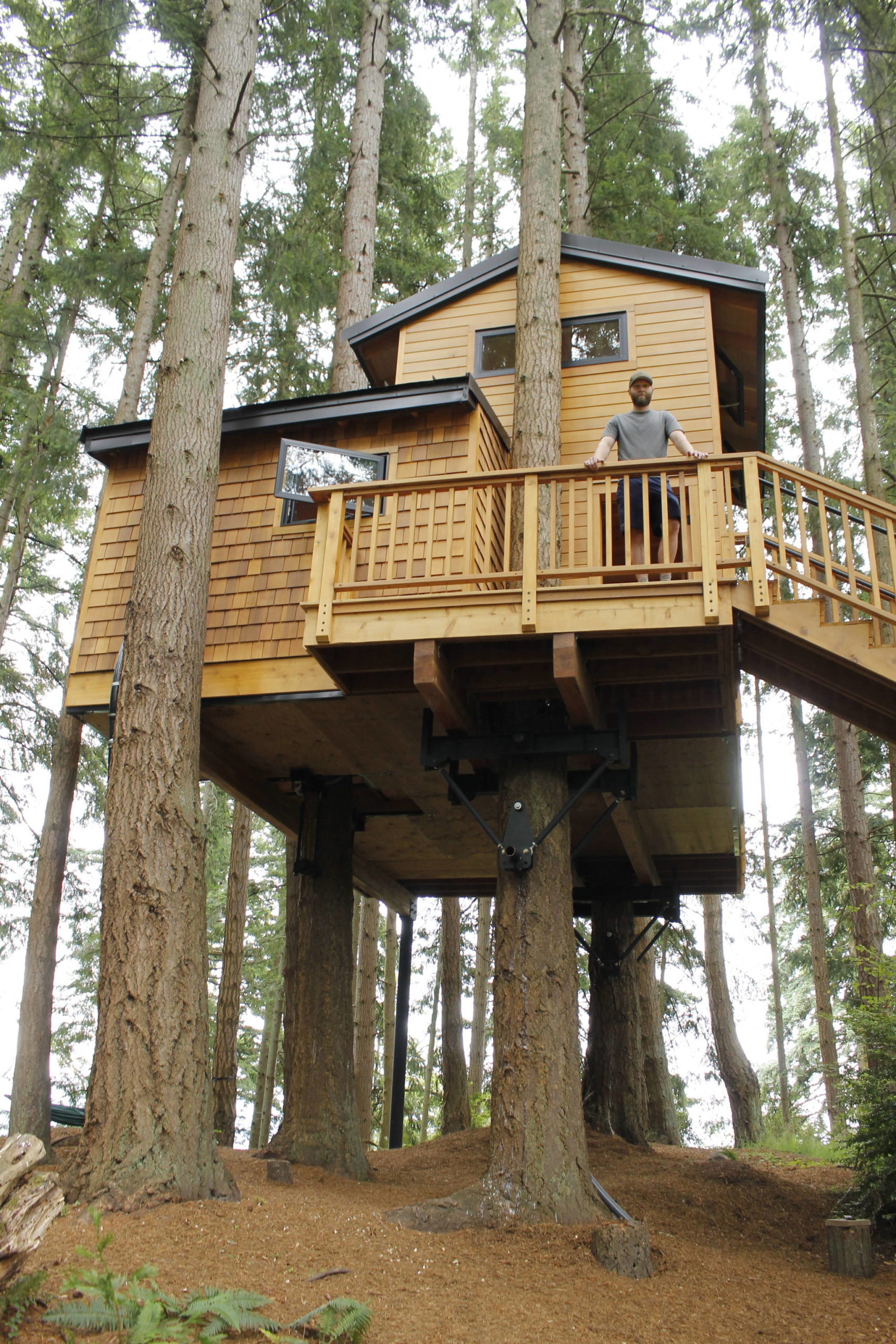 Max Lindsay-Thorsen stands on the deck of Treehouse Whidbey, a recently finished vacation rental in Clinton. On a windy day, guests can feel the house moving with the trees. (Photo by Kira Erickson)