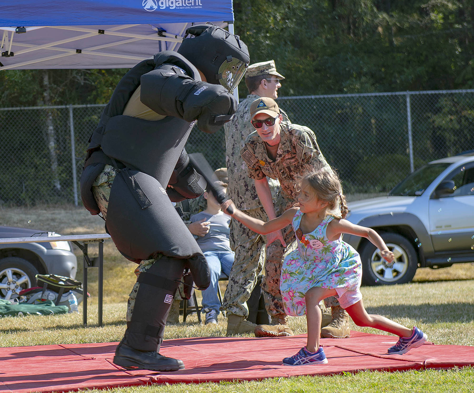 190704-N-HC646-0252 OAK HARBOR, Wash. (August 6, 2019) Master-at-Arms 1st Class Nick Fortune gives instruction during a take down demonstration to visitors in attendance of National Night Out on Fort Nugent Park. National Night Out is an annual community-building campaign that promotes police-community partnerships and neighborhood camaraderie. (U.S. Navy photo by Mass Communication Specialist 2nd Class Marc Cuenca/Released)