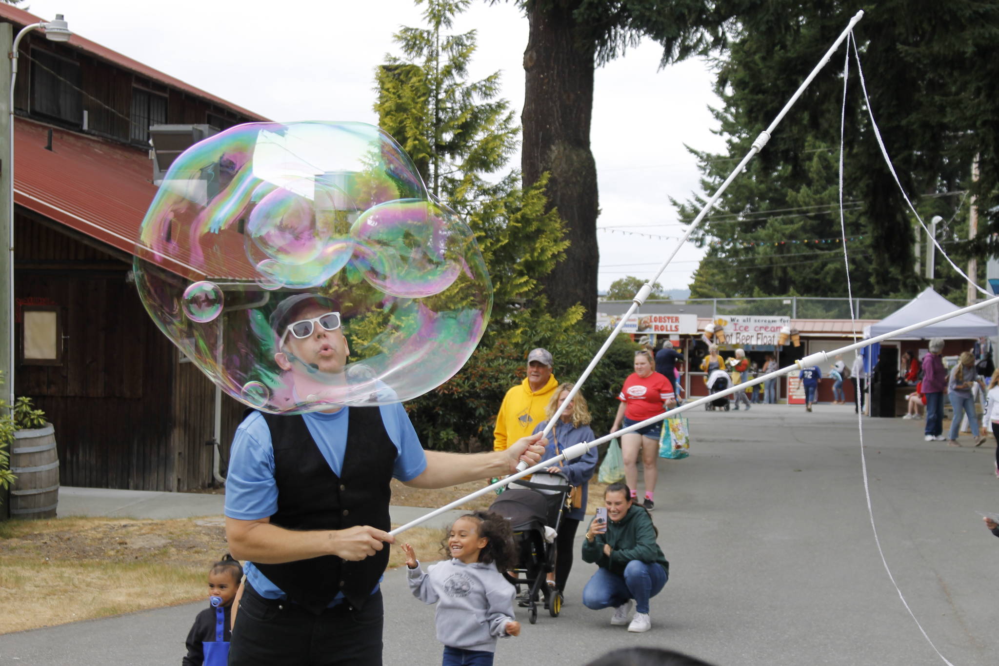 Bubble Guy Matt Henry blows a big bubble for children to chase at the Whidbey Island Fair Thursday. The performer is a regular fixture at the fair, which runs through Sunday. (Photo by Kira Erickson/South Whidbey Record)