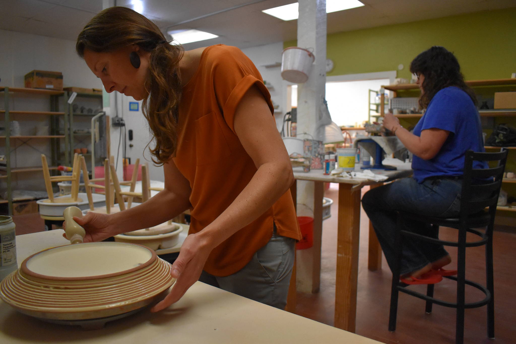 Cara Jung, left, and Tricia Vanslageren work on their art at Whidbey Clay Center in Freeland. The two will be joined by two more artists there during the Whidbey Working Artists Summer Open Studio Tour. (Photo by Emily Gilbert/Whidbey News-Times)
