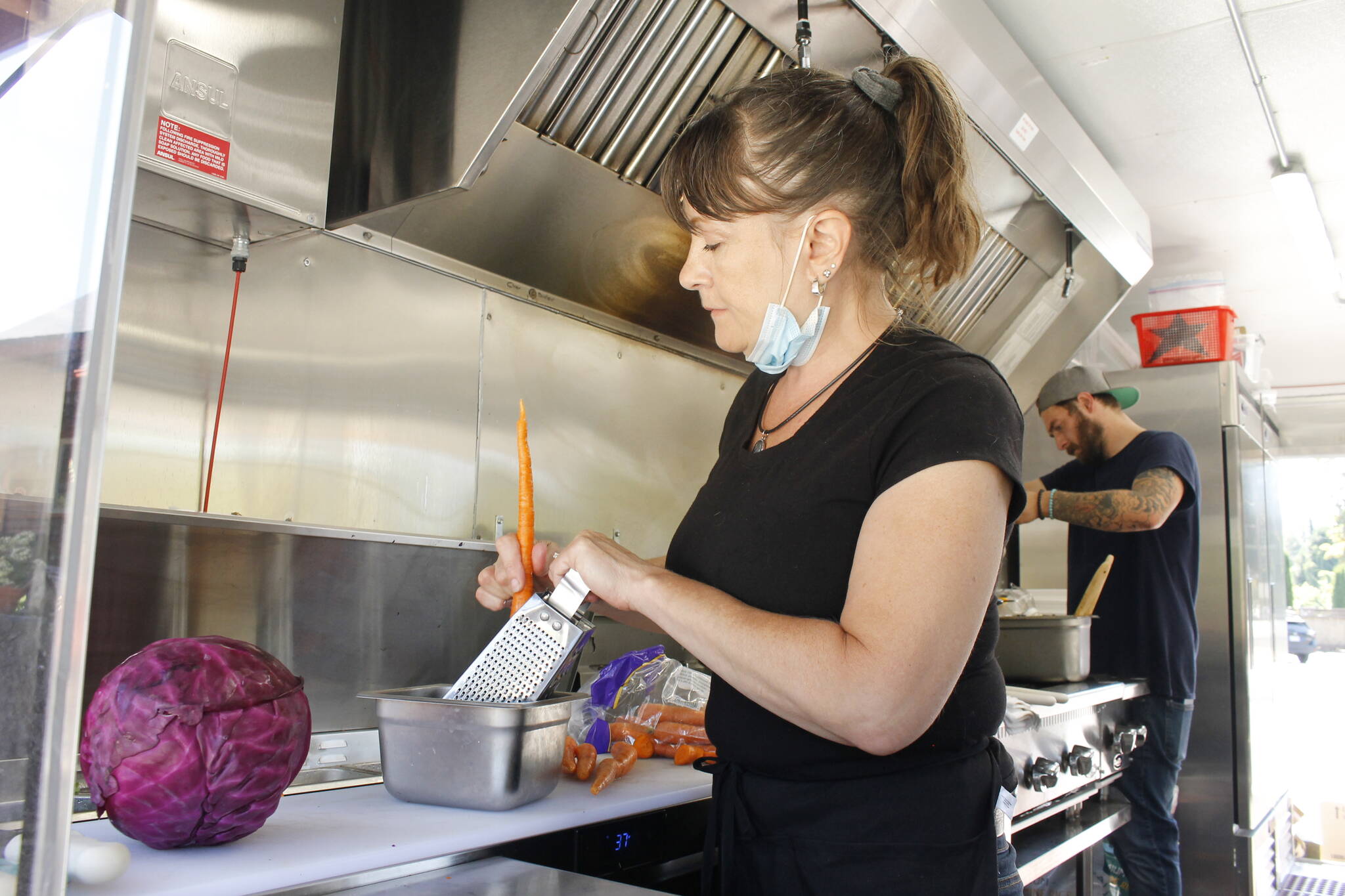 Photos by Kira Erickson/South Whidbey Record
Employee Kim McLain grates carrots for a salad. Below, a serving of chicken teriyaki from IC Teriyaki.