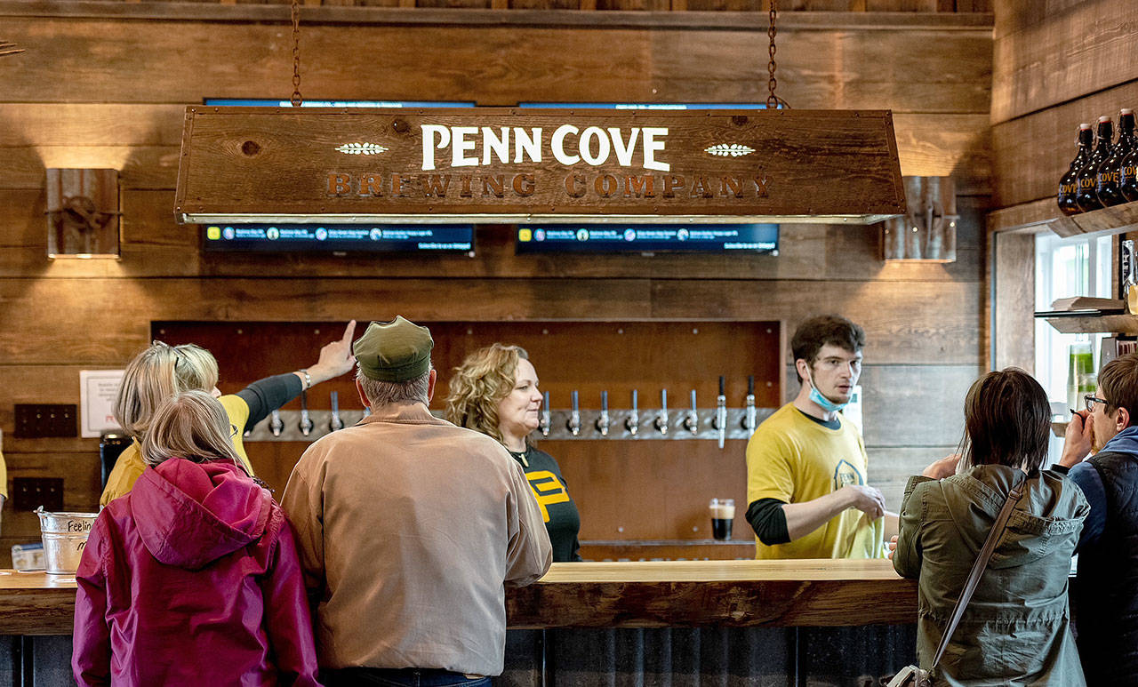 Penn Cove employees serve customers during the brewery’s grand opening celebration of its new location in Freeland over Memorial Day weekend. (Tyler Rowe / Cold Pizza Creative)