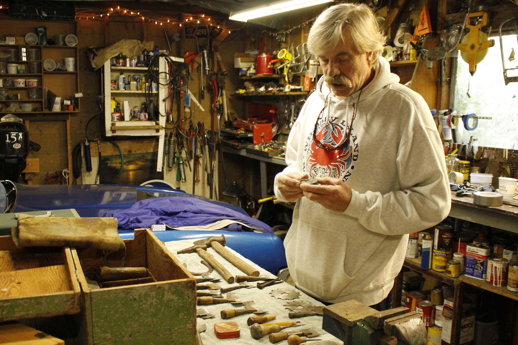 Photo by Kira Erickson/South Whidbey Record
South End picker John Norris examines the lock of an old toolbox he recently acquired from a Whidbey resident who was moving off the island. The old lock, which could potentially be 100 years old, bears an S insignia that is eerily similar to the Seattle Kraken logo.