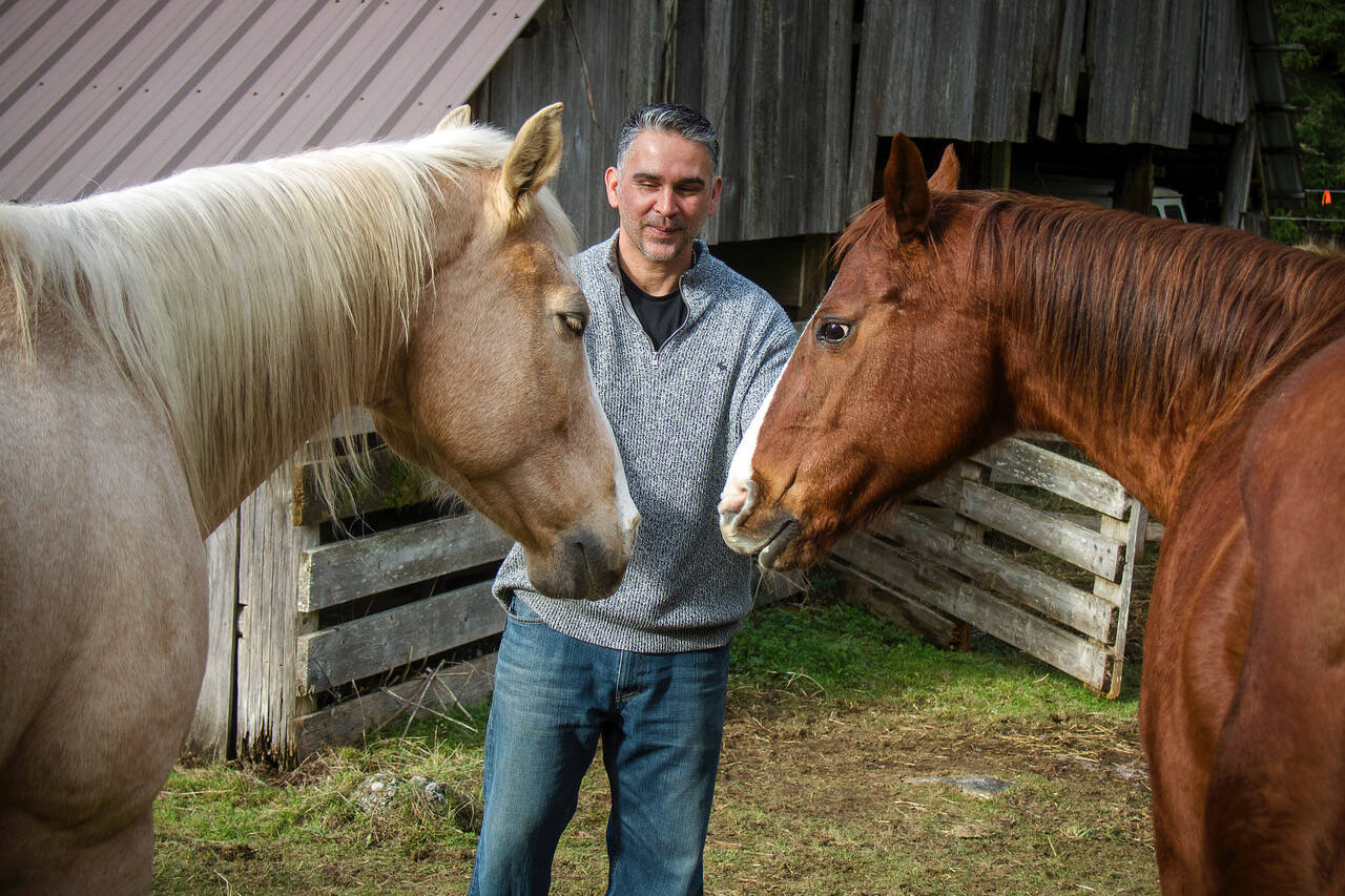 Photo by Dave Welton
Drew Breton greets rescue horses I-Candee and Sis.