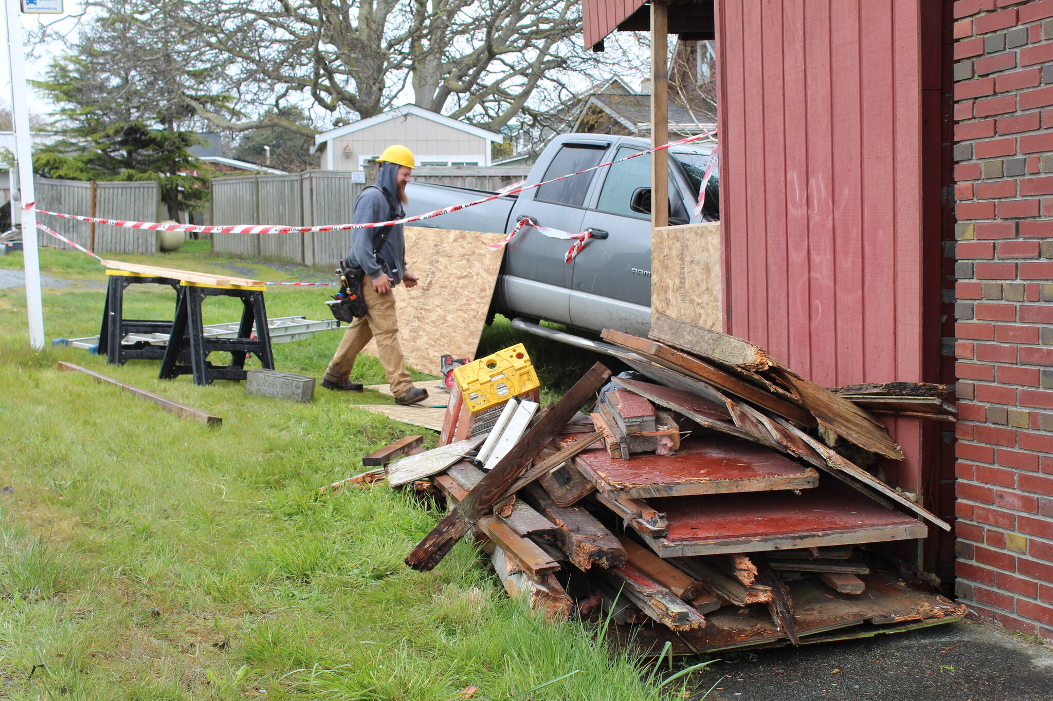 Construction workers repair damage done by a truck that crashed into the wooden building adjacent to Penn Cove Pottery. As of Monday afternoon, the truck had not been removed due to structural integrity concerns at the site of the accident. (Photo by Karina Andrew/Whidbey News-Times)