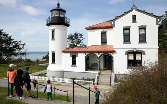 A group of children take a look at the restored Admiralty Head Lighthouse Thursday, April 7, 2022, near Coupeville, Washington. (Ryan Berry / The Herald)