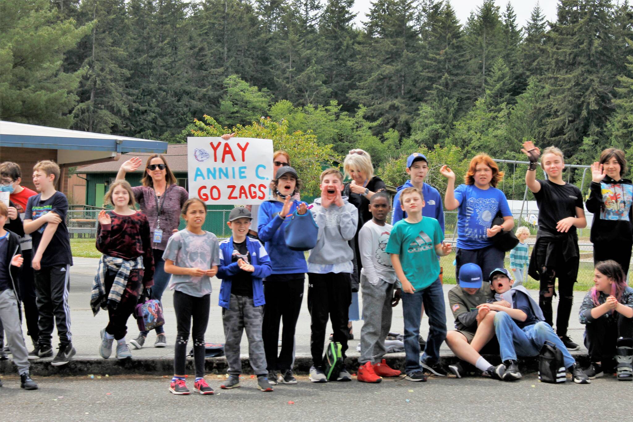 Children and faculty members standing outside of South Whidbey Elementary School cheered as the parade of high school seniors passed by them. (Photo by Kira Erickson/South Whidbey Record)