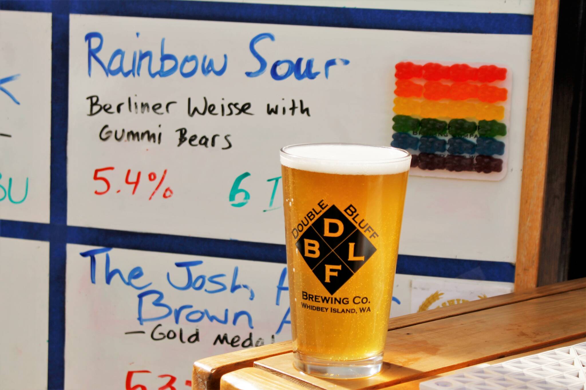 A pint of Rainbow Sour glimmers in the sunlight. The wheat beer is made with 10 pounds of gummy bears, which give the beer a subtly sweet taste. (Photo by Kira Erickson/South Whidbey Record)