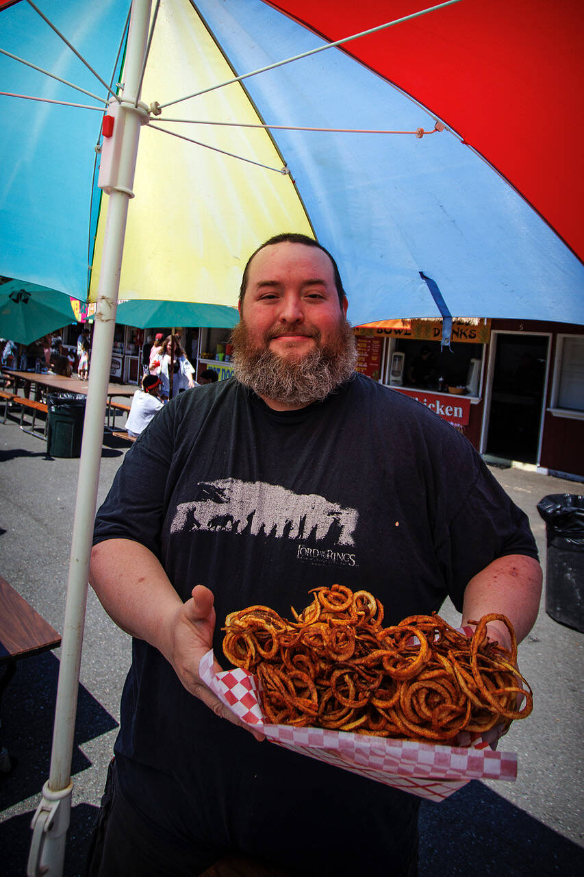There’s no shortage of fried food at the Whidbey Island Fair. Steve Ulibarri enjoys a heaping helping of curly fries.