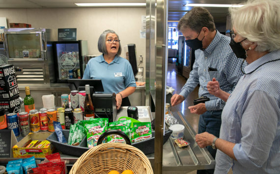 Maria Rios, a galley cashier, helps Frank and Fran Butler, of Washington, D.C., with food purchases aboard the Suquamish ferry between Mukilteo and Clinton. The galley is among several reopened after being closed over two years due to the pandemic. The galley of the Tokitae, the other boat on the Mukilteo-Clinton route, remains closed for now. (Ryan Berry / The Herald)