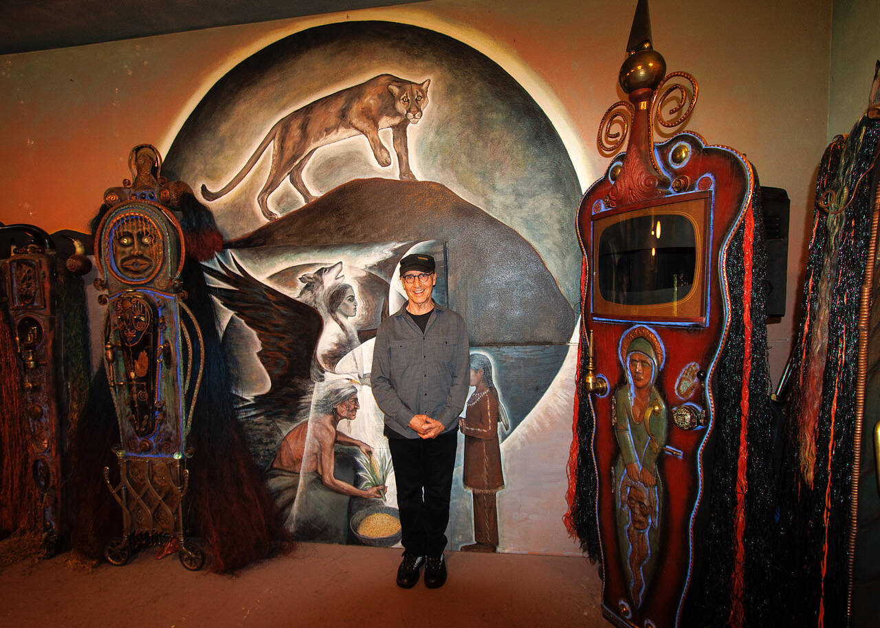 Photos by David Welton
Jerry Wennstrom in front of a luminous mural of a mountain lion and Native American figures that he painted in his gallery.
