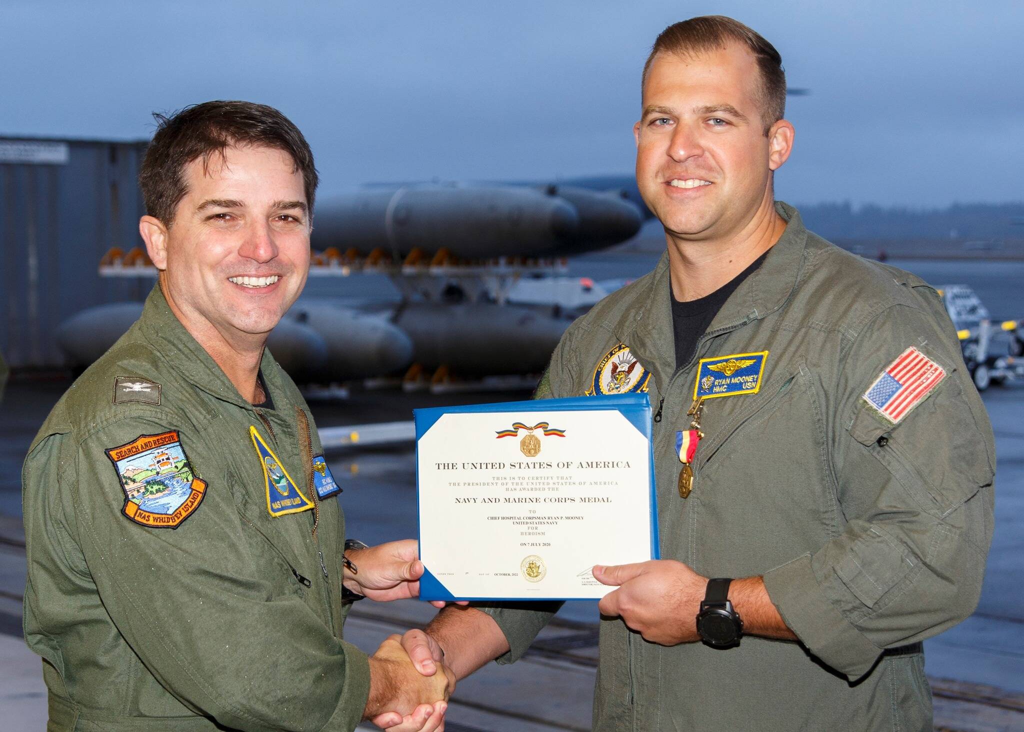 Capt. Eric Hanks, left, presents Chief Ryan Mooney with the Navy Marine Corps Medal Oct. 31.