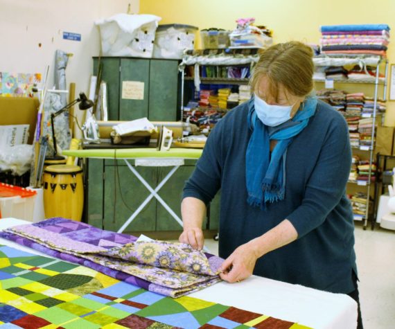 File photo/South Whidbey Record
Luanne Seymour, photographed here in 2021, shows a few different-sized quilts that Whidbey Blanket Makers sewed. The group continues to meet at Create Space.
