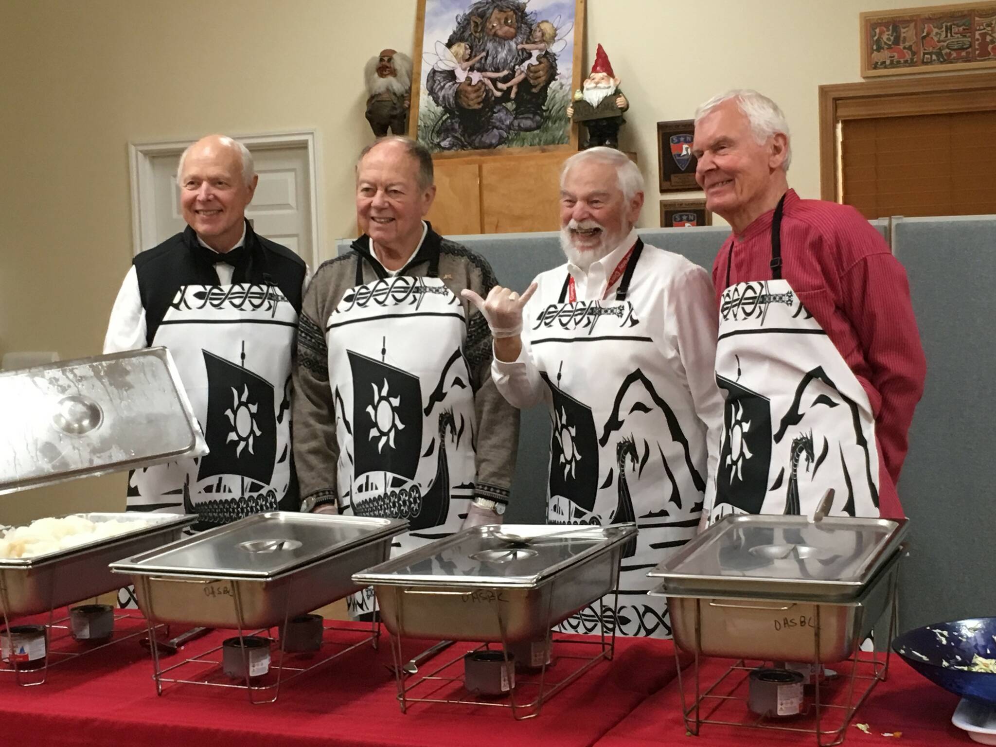 From left, Loran Haworth, Dick Johnson, Pete Berg and Bob Fordserve Lutefisk at the Whidbey Nordic Lodges 2019 dinner. (Photo provided)