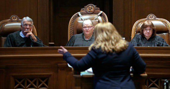 Justice Charles Johnson, then-Chief Justice Mary Fairhurst (center) and Justice Barbara Madsen listen as Michele Earl-Hubbard, an attorney for a media coalition led by the Associated Press, speaks during a hearing before the Washington Supreme Court in Olympia, in June, 2019, regarding a case to determine whether state lawmakers are subject to the same disclosure rules that apply to other elected officials under the voter-approved Public Records Act. The Washington Supreme Court ruled Thursday, Dec. 19, 2019, that the Public Records Act does fully apply to state lawmakers in a 7-2 decision. (Elaine Thompson / Associated Press)