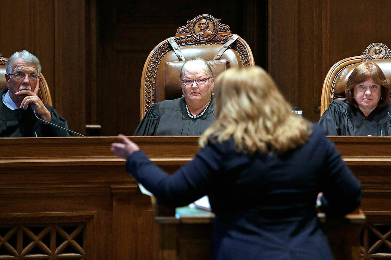 FILE - In this June 11, 2019 file photo, Justice Charles Johnson, left, Chief Justice Mary Fairhurst, center, and Justice Barbara Madsen, right, listen as Michele Earl-Hubbard, an attorney for a media coalition led by The Associated Press, speaks during a hearing before the Washington Supreme Court in Olympia, Wash., regarding a case that will determine whether state lawmakers are subject to the same disclosure rules that apply to other elected officials under the voter-approved Public Records Act. The Washington Supreme Court ruled Thursday, Dec. 19 that the Public Records Act does fully apply to state lawmakers by a 7 to 2 decision. (AP Photo/Elaine Thompson, File)