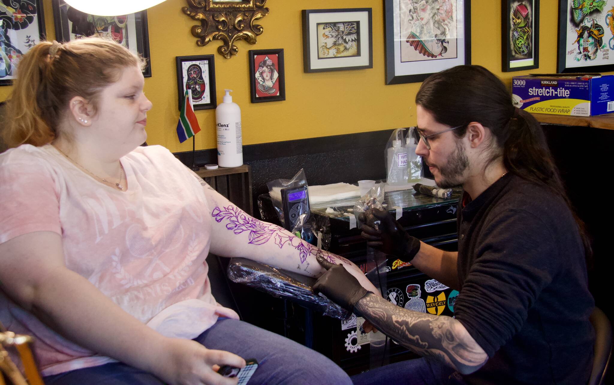 Photo by Rachel Rosen/Whidbey News-Times
Kyle-John McKenzie, who recently moved from South Africa, tattoos a floral piece on Jessica Broadfield.