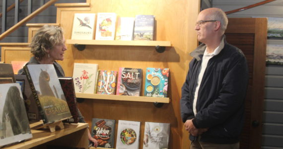Photo by Karina Andrew/Whidbey News-Times
Meg Olson, left, tells Rep. Rick Larsen about the troubles her shop, Kingfisher Bookstore, encountered during the last king tide.