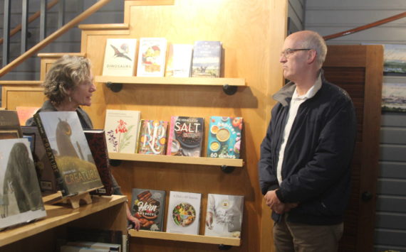 Photo by Karina Andrew/Whidbey News-Times
Meg Olson, left, tells Rep. Rick Larsen about the troubles her shop, Kingfisher Bookstore, encountered during the last king tide.