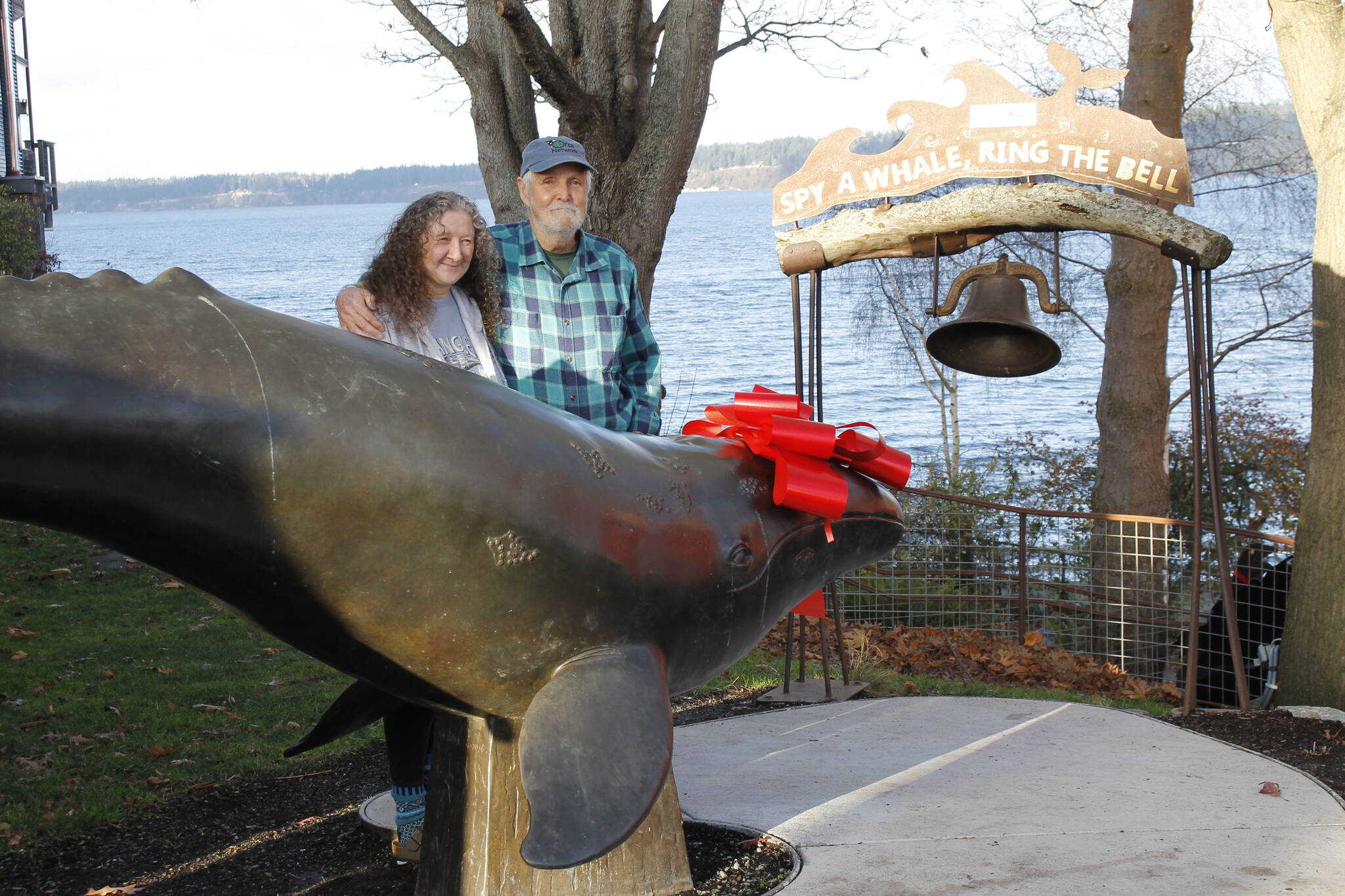 Susan Berta and Howard Garrett stand near the whale bell in 2021. (File photo)
