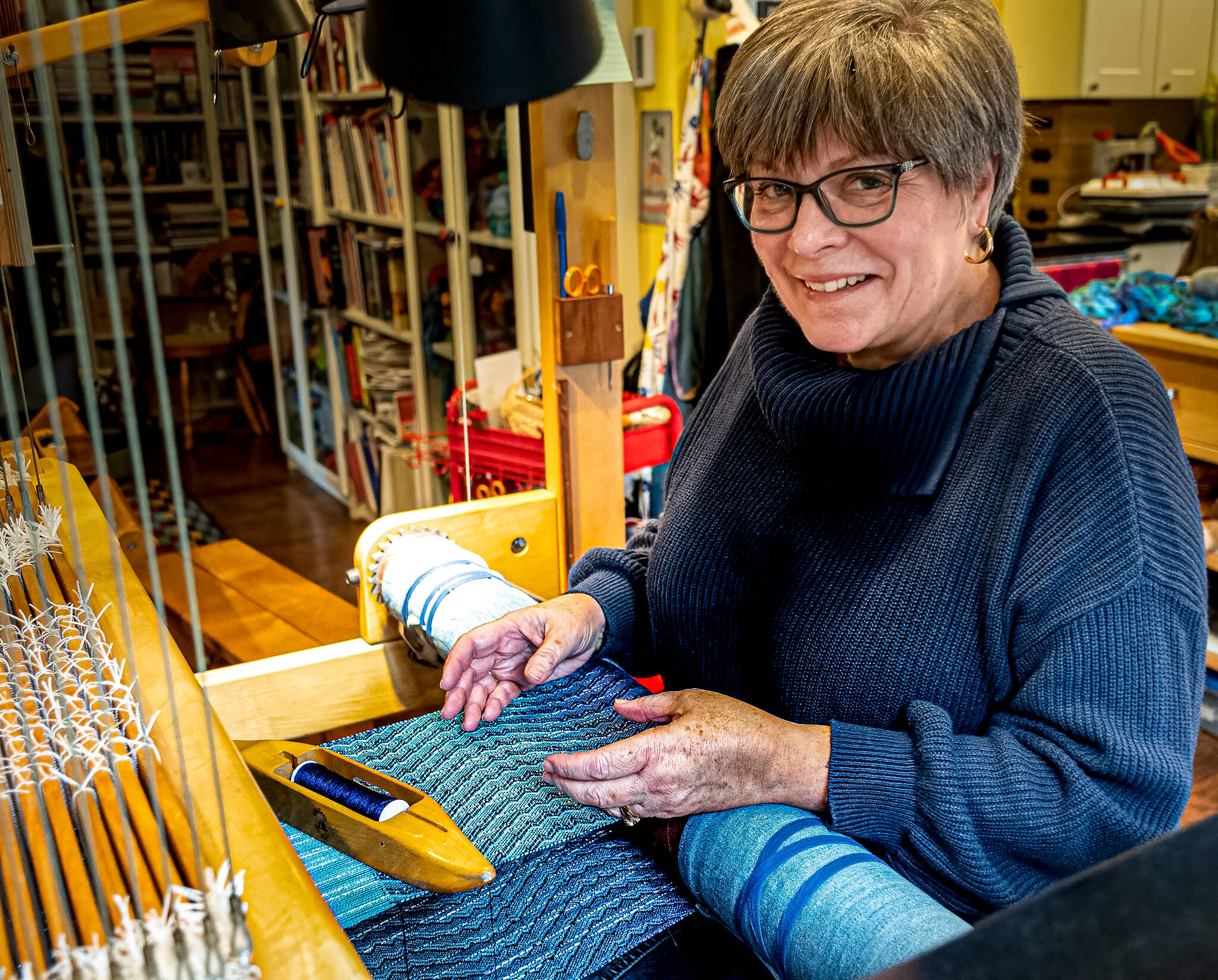 Photo by Dennis Browne
Weaver Danette Sulgrove works at the loom, creating an art piece she calls the storycloth. The project is a collaboration between Sulgrove and Charles LaFond, a potter.
