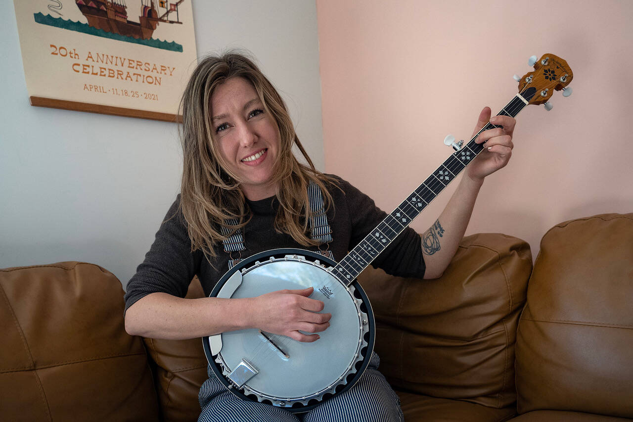 Gabbi Korrow practices playing the banjo in her living room. (Photo by David Welton)