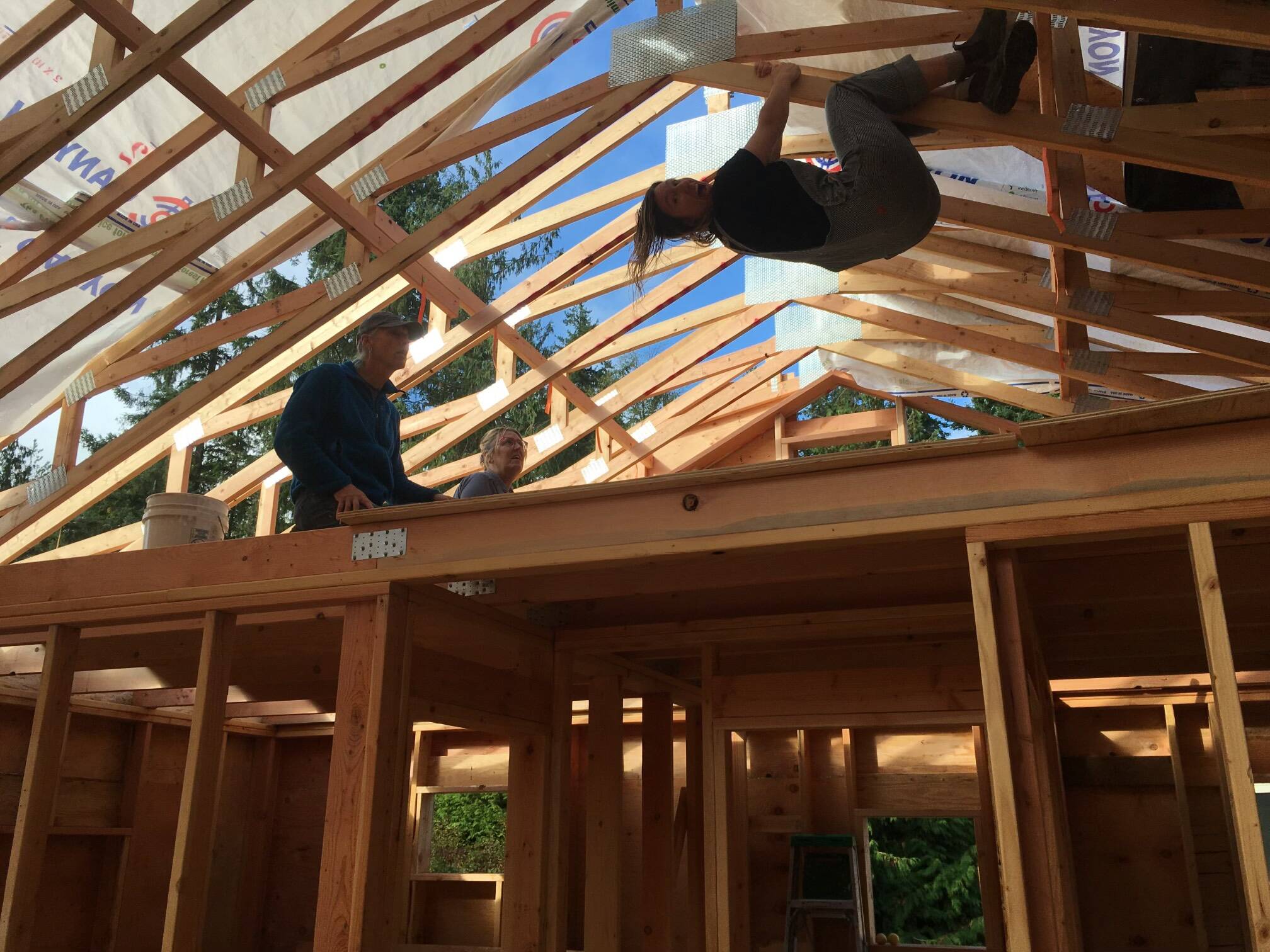 Gabbi Korrow hangs from the rafters during construction of her home. (Photo provided)