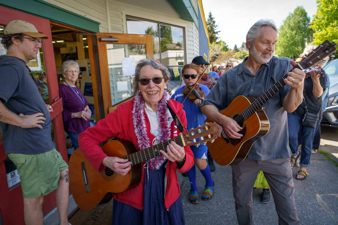 Linda Good and Karl Olsen, minister of music at Trinity Lutheran Church in Freeland, lead a parade in song on May 20. (Photo by David Welton)