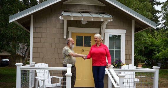 Photos by David Welton
Bon Thayer, THiNC site manager, and Deborah Hedlund, a member of the organization’s board, shake hands at the completion of the tiny house project.