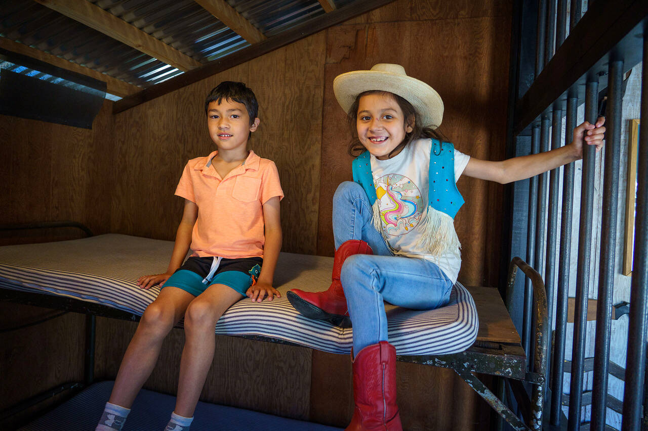 Kindergartener Aiden Rasmussen and second grader Athena Guerrero spend some time in the Cowboy Town jail. (Photo by David Welton)