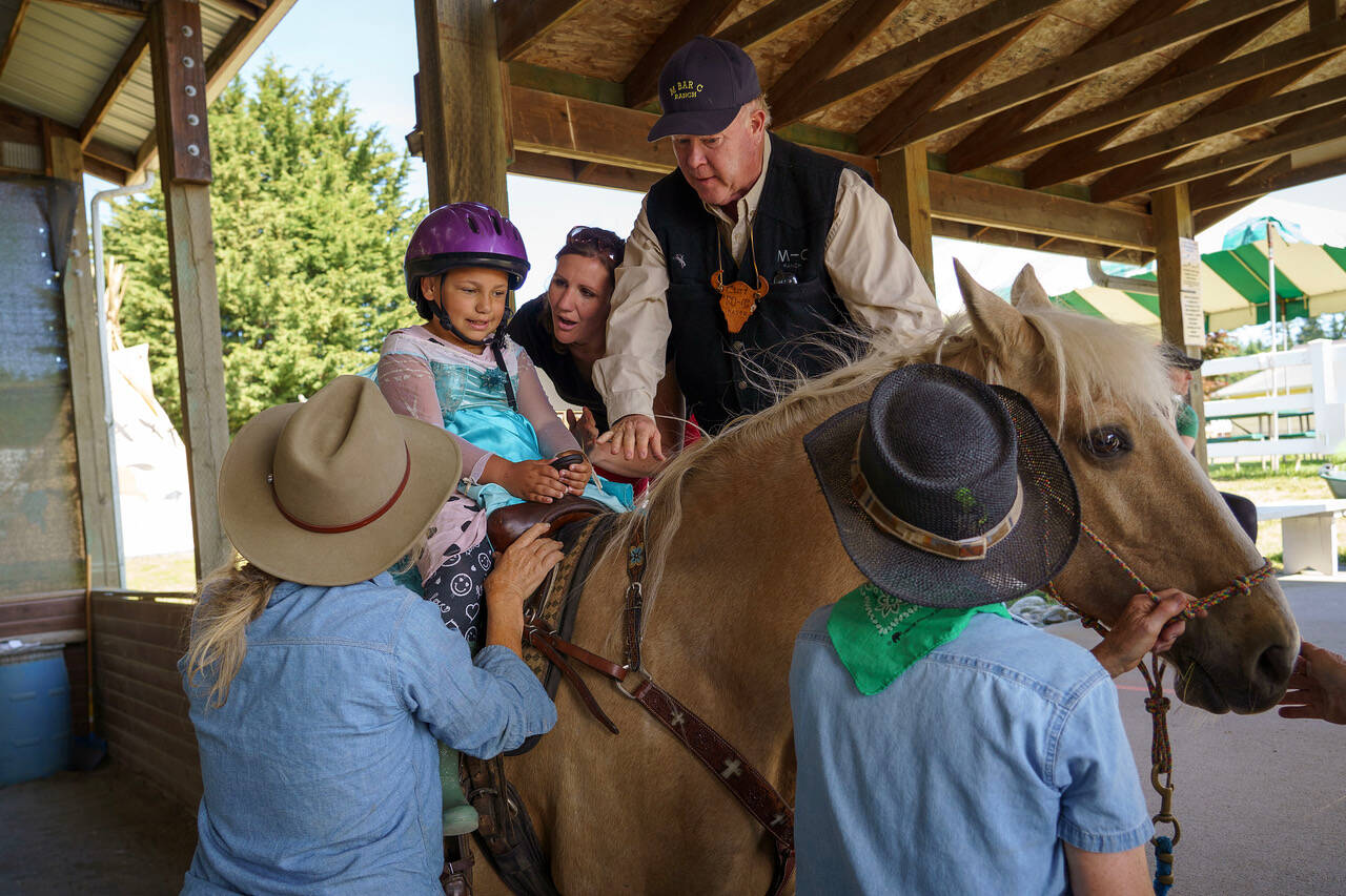 First grader Aubrielle Hunt takes her turn riding a horse at the M-Bar-C Ranch. (Photo by David Welton)
