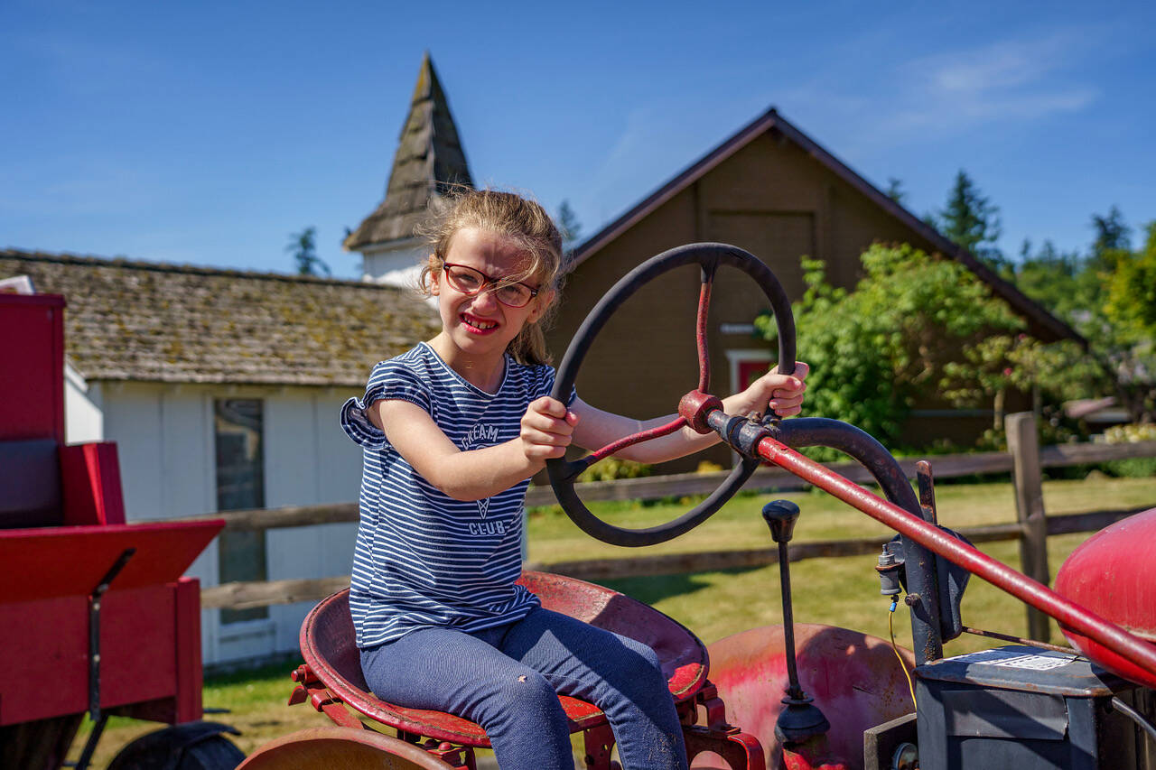 Second grader London Connell practices driving a toy tractor at the M-Bar-C Ranch. (Photo by David Welton)