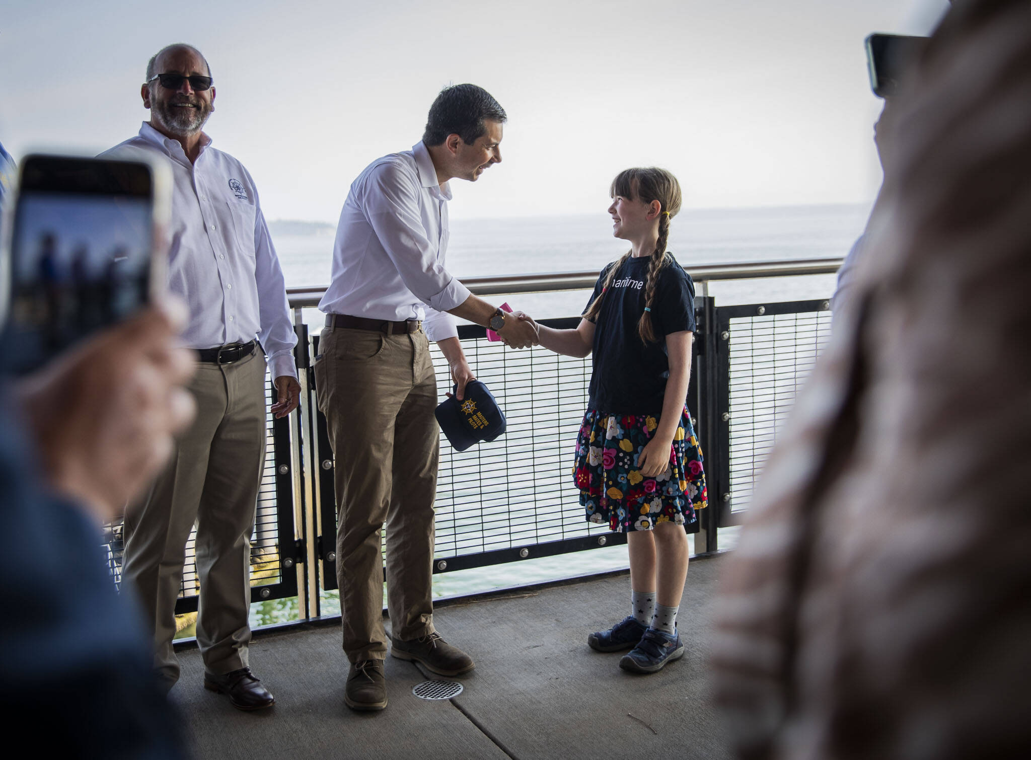 U.S. Transportation Secretary Pete Buttigieg shakes hands while taking photos with those gathered for his visit at the Mukilteo Ferry Terminal on Thursday, July 6, 2023. (Olivia Vanni / The Herald)